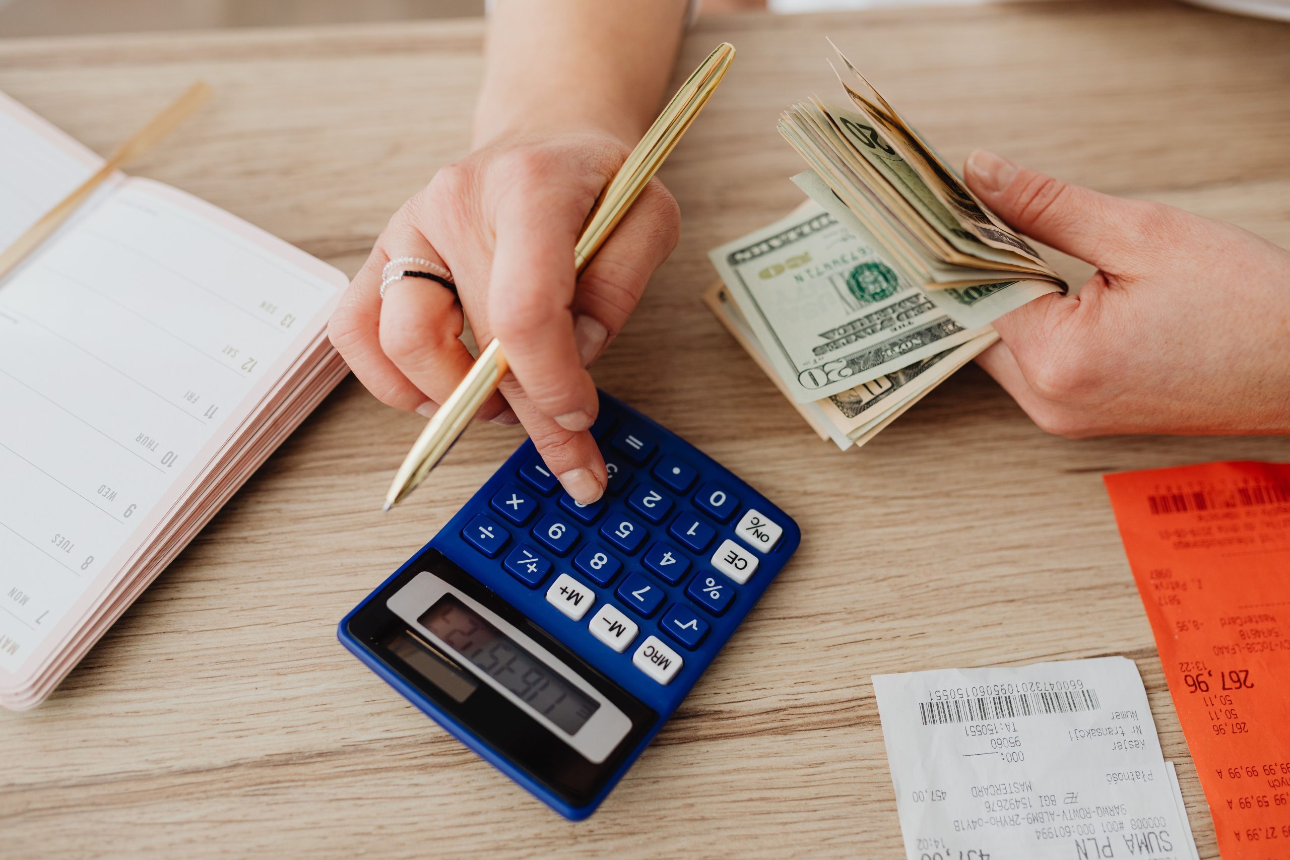 Mains manipulant cash et calculatrice budgétaire