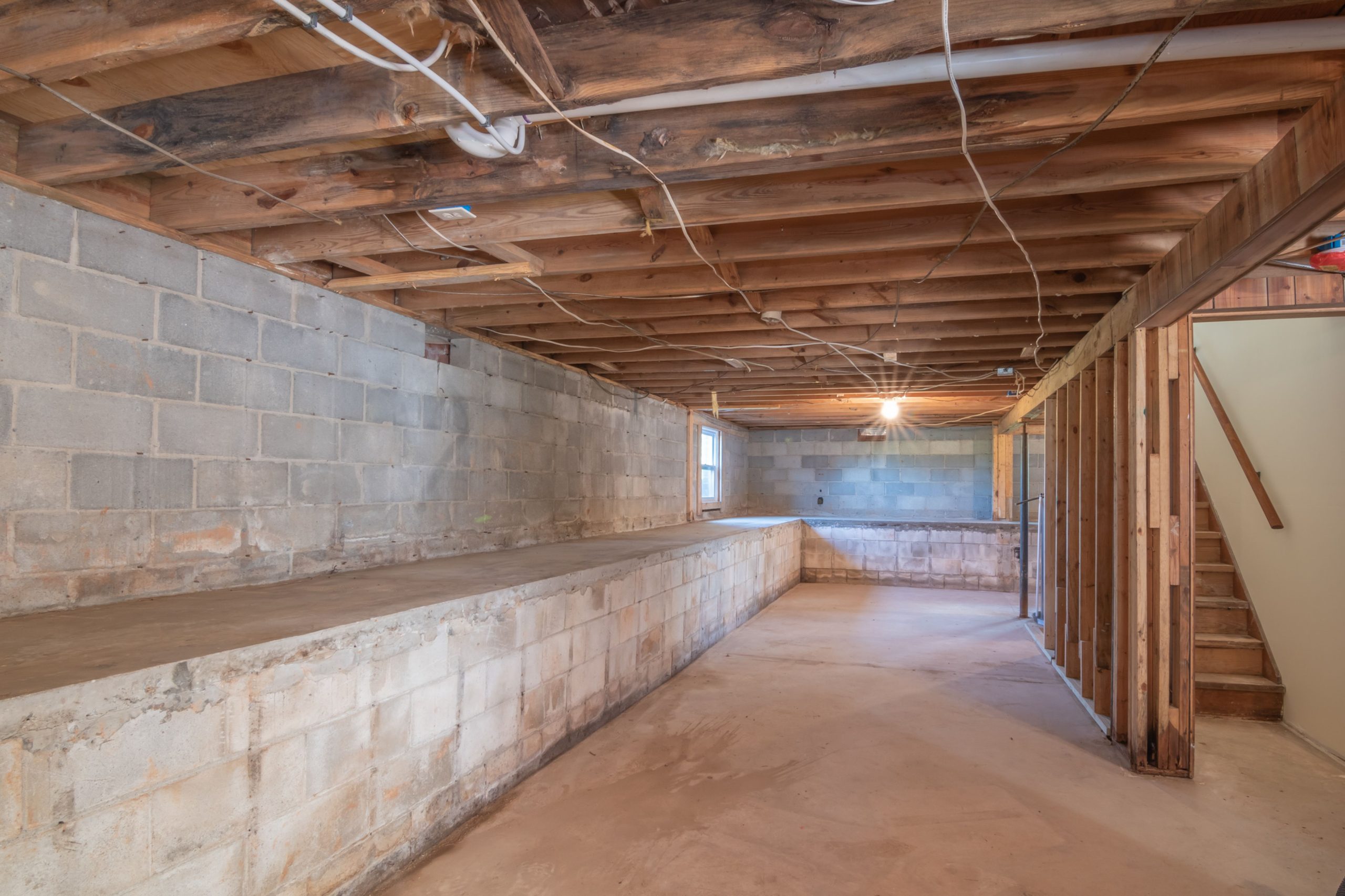 Sous-sol exposé poutres bois murs béton